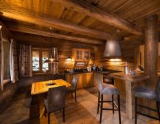 Chaletdorf Auszeit Küche und Wohnbereich in einem rustikalen Chalet im Chaletdorf Auszeit ganz in Holzoptik gehalten