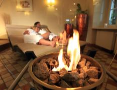 Romantik Hotel Im Weissen Rössl Zwei Gäste kuscheln im Ruheraum mit offenem Kamin im Romantik Hotel Im Weissen Rössl