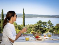 Hotel Kvarner Palace Eine Dame genießt das Frühstück im Hotel Kvarner Palace mit Blick aufs Meer