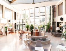 Lobby mit großen Glasfronten und Sitzgelegenheiten im Grand Hotel Portoroz