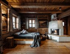 Blick in ein Doppelzimmer in einem Chalet mit offenem Kamin im Chaletdorf Auszeit
